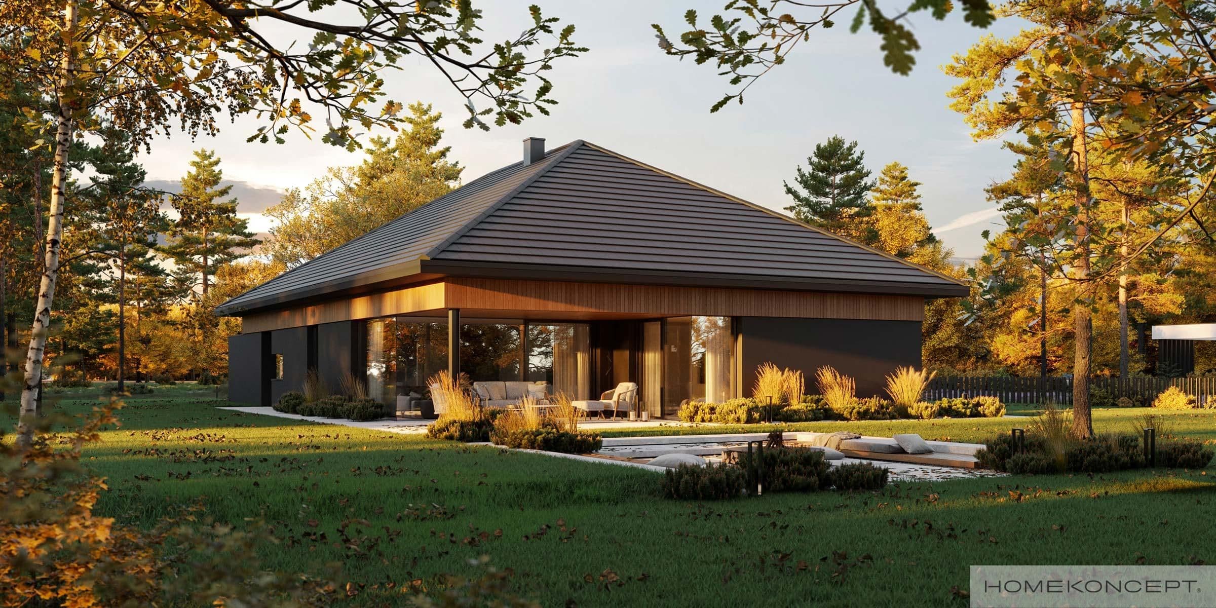Modern single-story house with large glass windows surrounded by autumn trees.